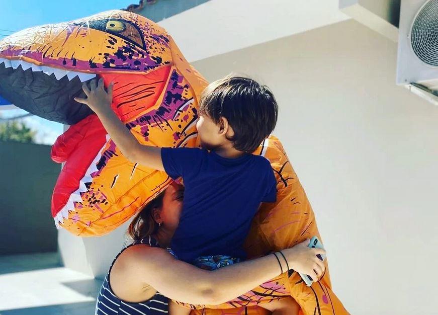 No litoral de São Paulo, um médico se veste de dinossauro para poder abraçar filho